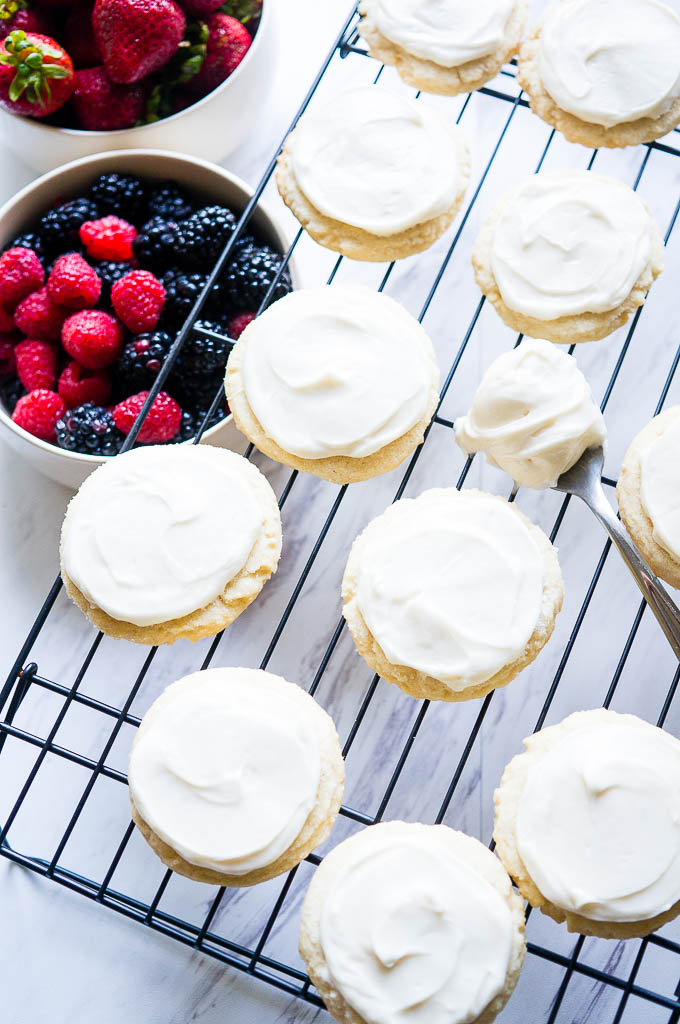 Patriotic Mini Fruit Pizzas.  A fun dessert for 4th of July with a classic sugar cookie base, a scrumptious cream cheese frosting, and your choice of red and blue fruit!