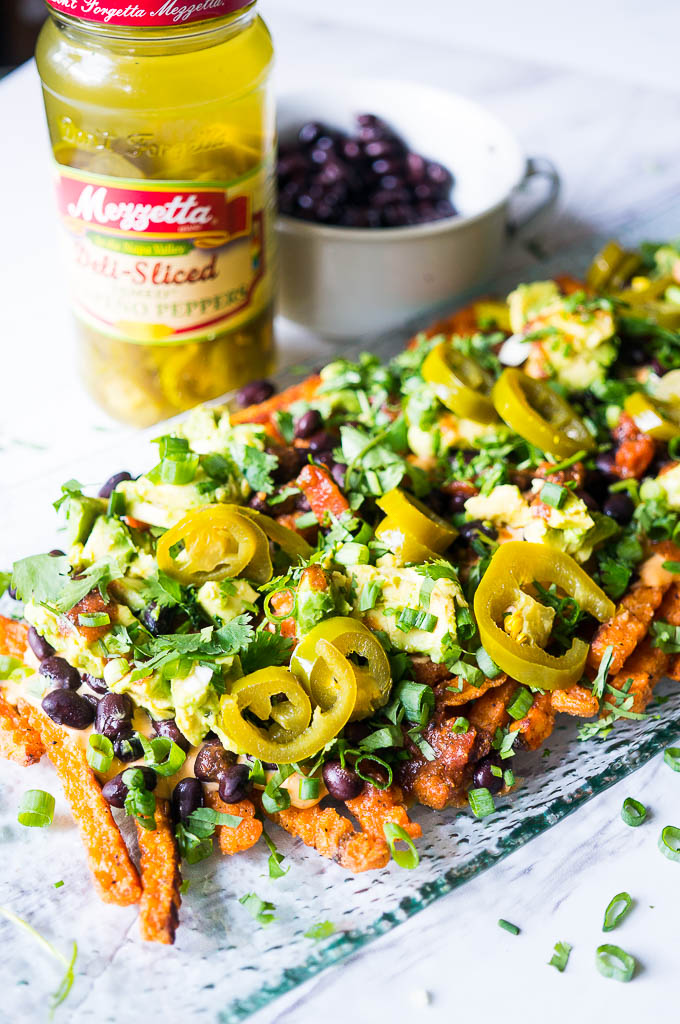 Loaded Sweet Potato Nacho Fries. Crispy sweet potato fries topped with queso, black beans, Mezzetta's spicy sliced jalapenos, and cilantro is the perfect summer appetizer!