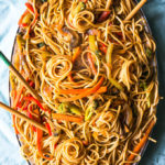 veggie lo mein with carrots on a light blue background