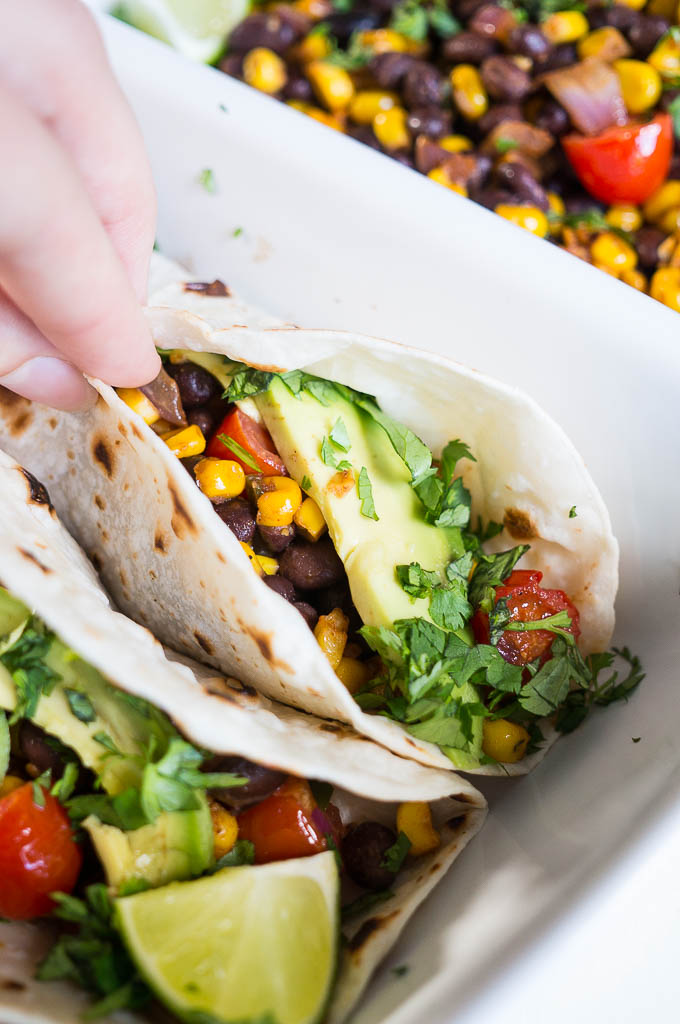 Corn, Black Bean, and Avocado Tacos - we're going meatless but still totally satisfying with these veggie loaded tacos!