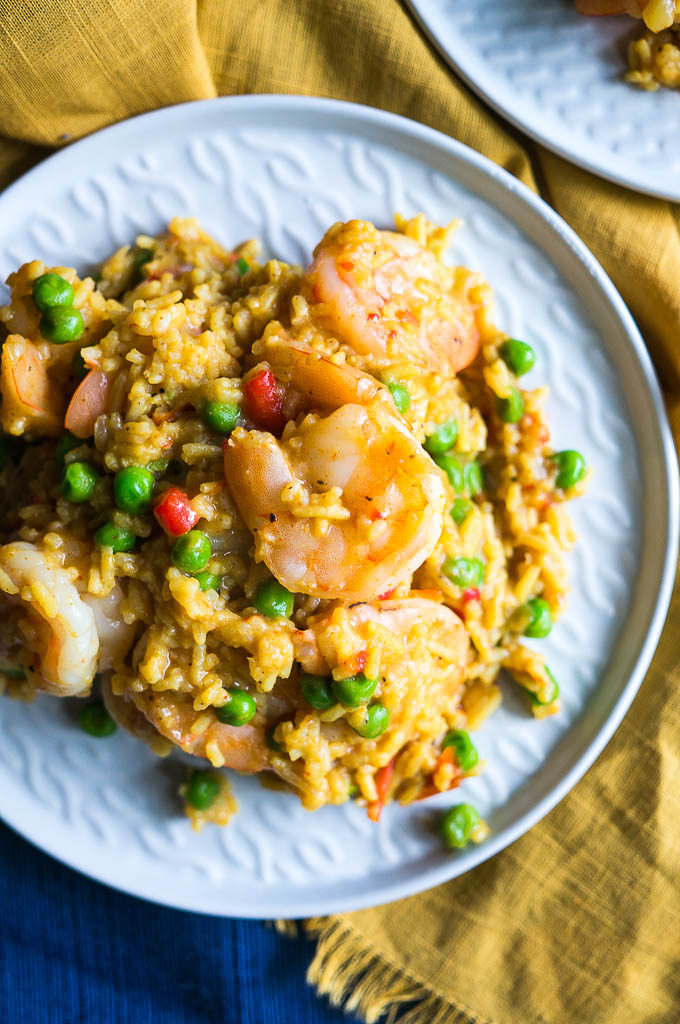 Shrimp paella on white plates with yellow and blue napkins
