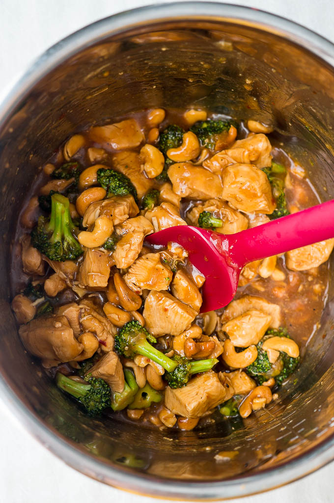 Cashew Chicken with Broccoli in the instant pot bowl with a red spatula.