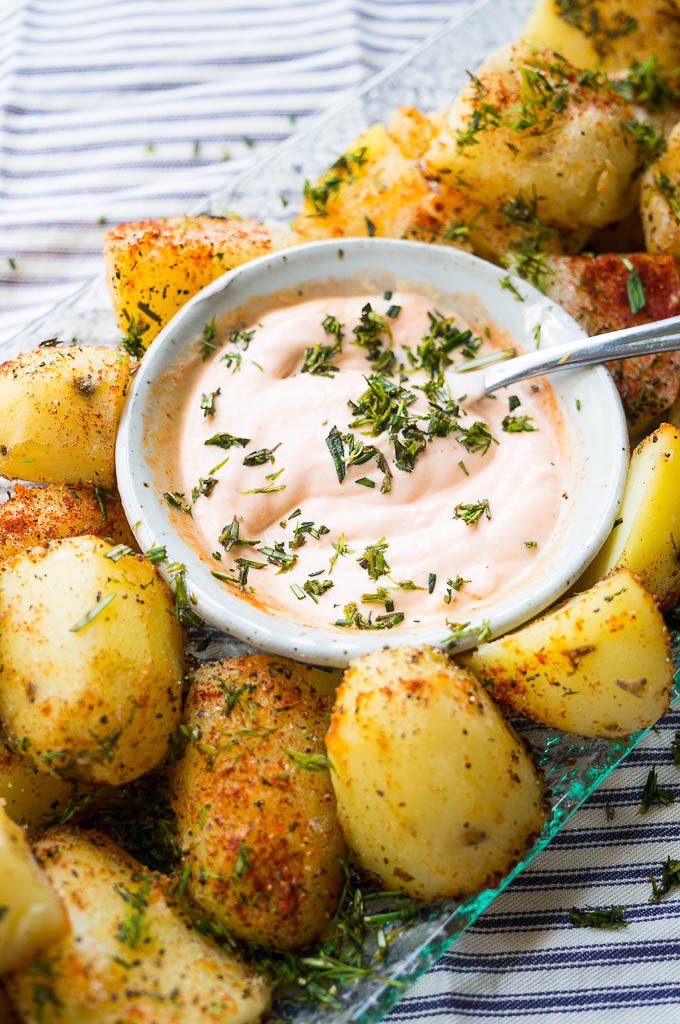 Herb Roasted Potatoes on a glass platter with dipping sauce.