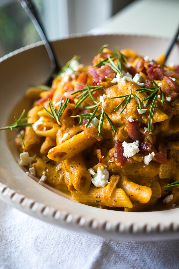 Creamy Pumpkin Pasta with Rosemary Sprigs in a tan bowl